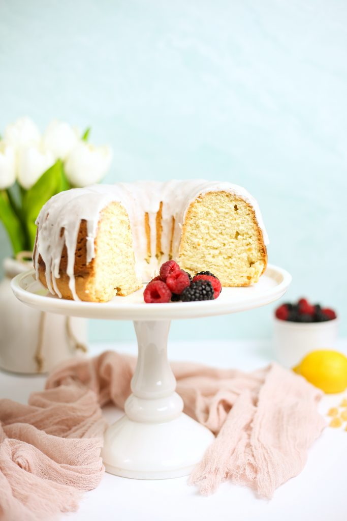 lemon ginger bundt cake on a display stand with berries